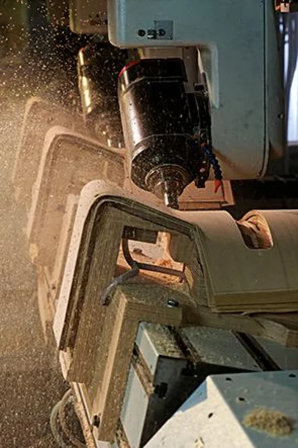 CNC-Konturfräsen bei der Bearbeitung von Stuhlformteilen. Das Spannen der Teile erfolgt mit Vakuum