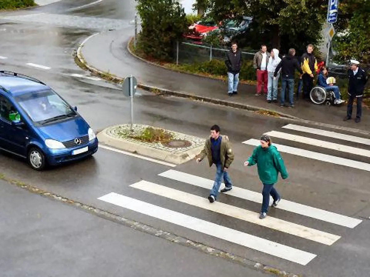 das richtige Überqueren der Straße wird unter den Augen von Polizeihauptkommissar Müller geübt.